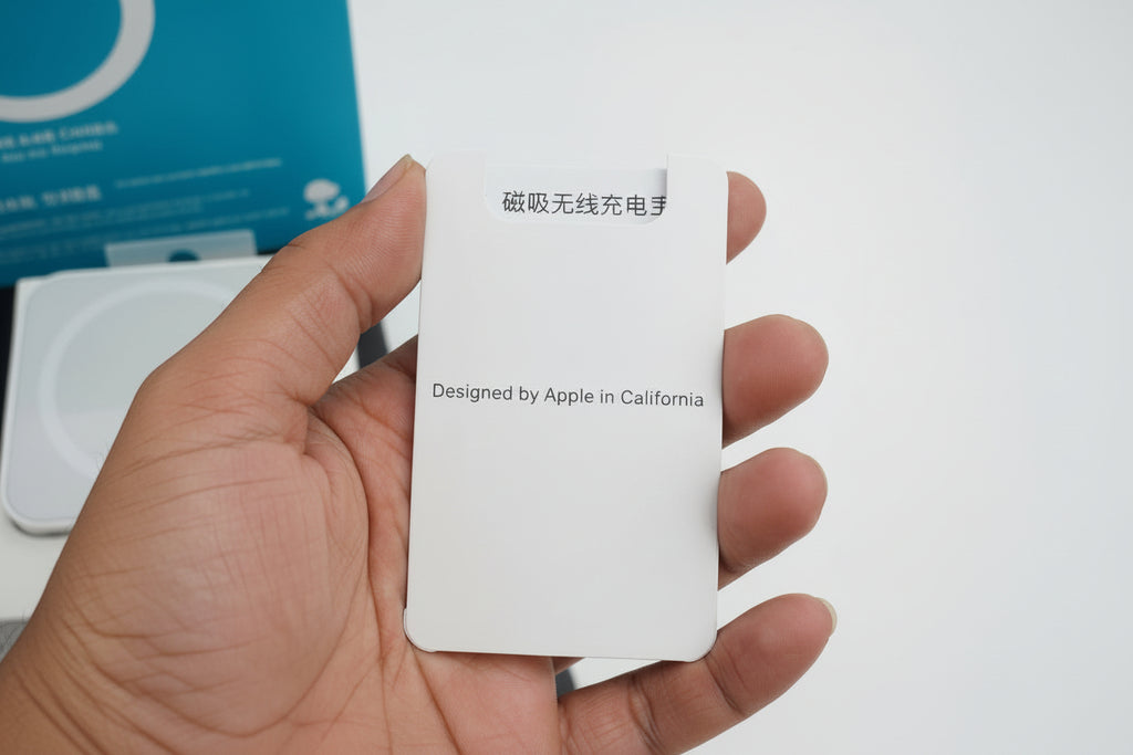 White card with text held by a hand, with a blurred background