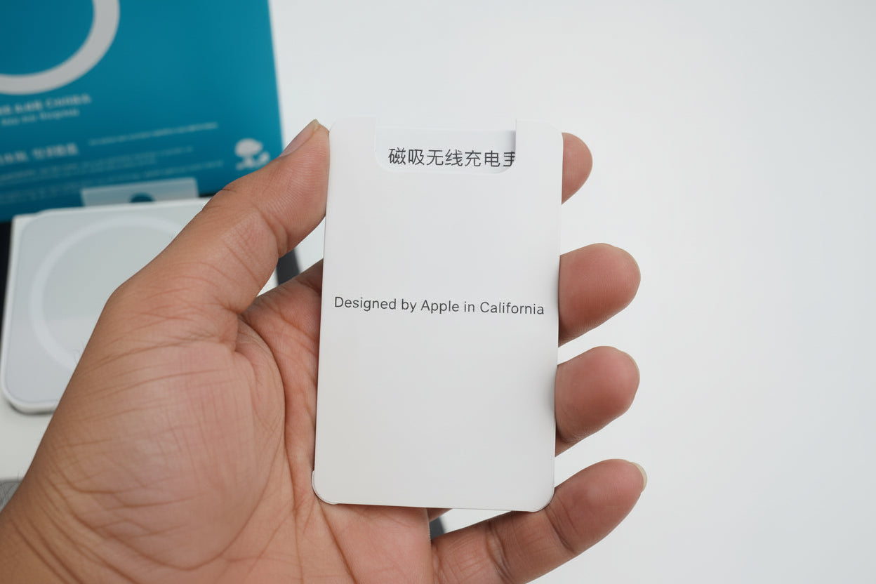 White card with text held by a hand, with a blurred background