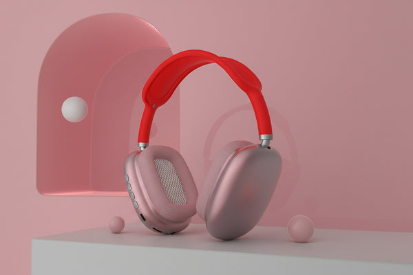 Pink headphones with red headband on a pink background