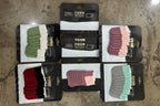 Collection of different colored foot pads in packaging on a textured surface